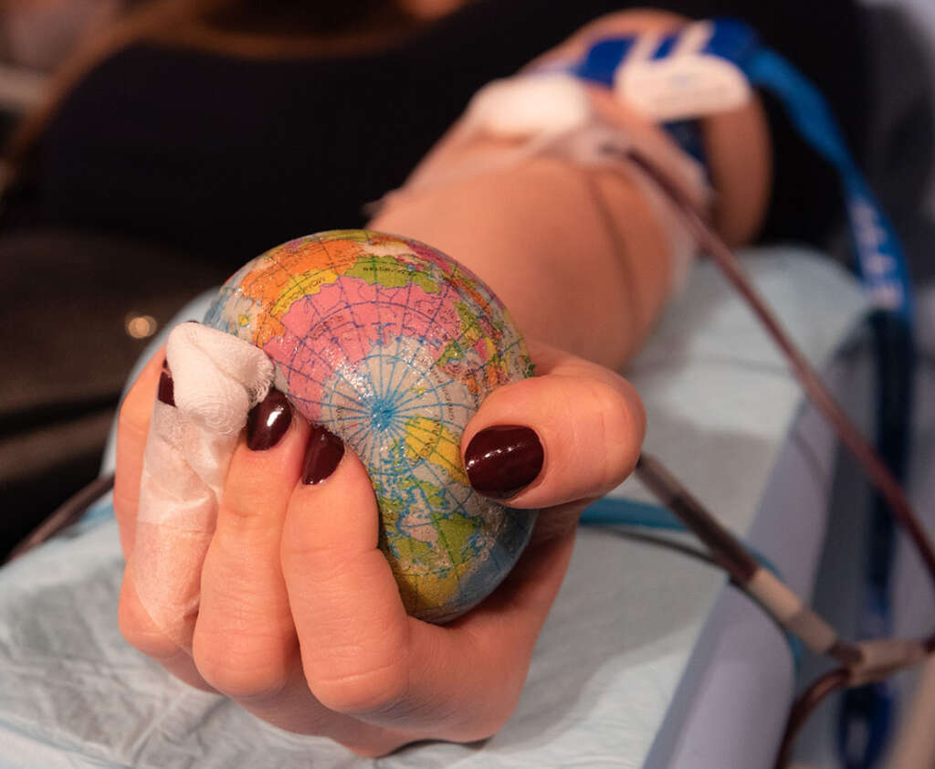 Woman with burgundy nails donates blood